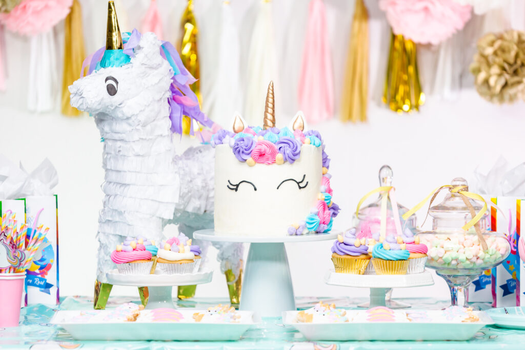 little girl birthday party table with unicorn cake cupcakes sugaer cookies